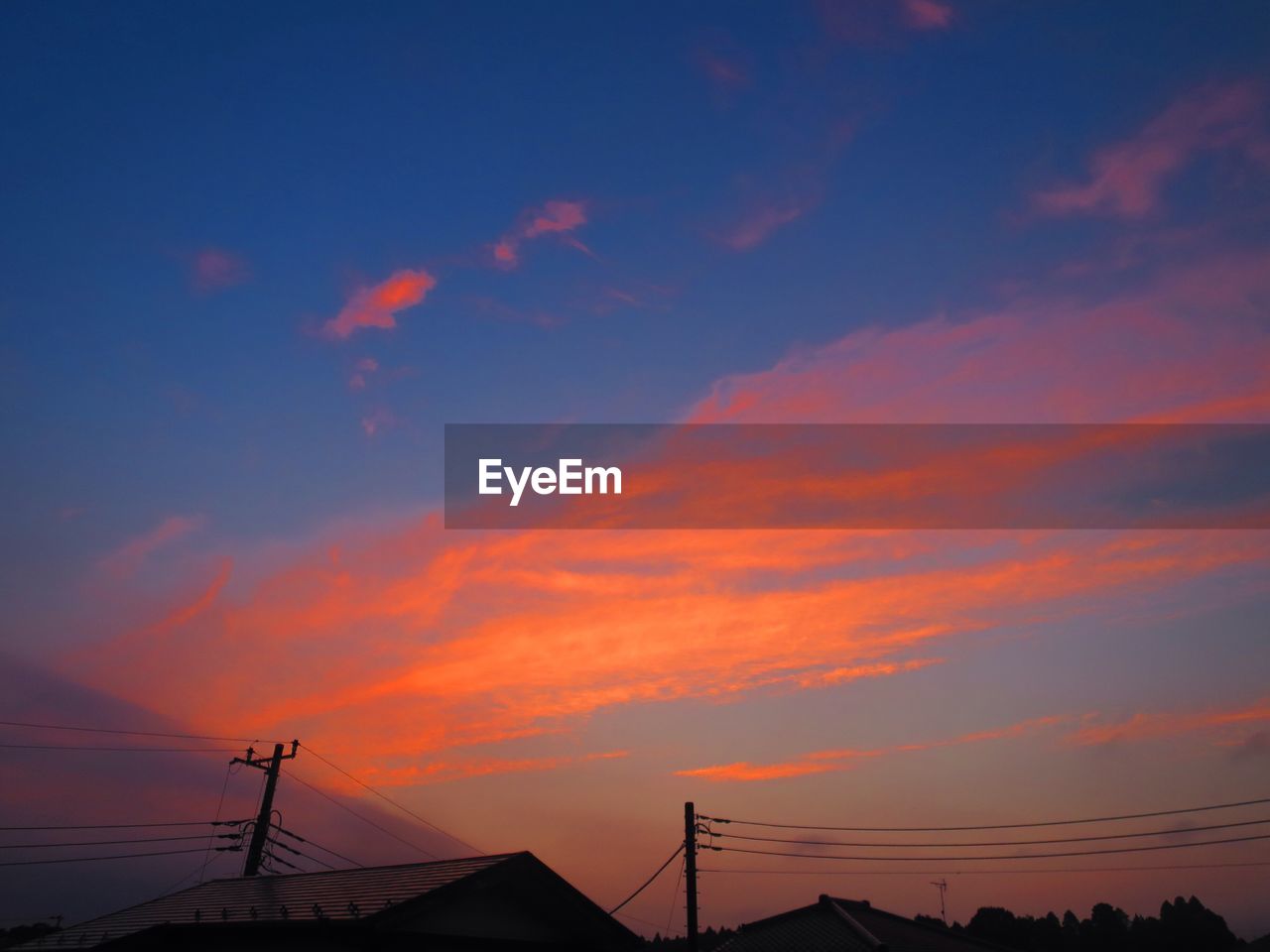 LOW ANGLE VIEW OF SILHOUETTE TELEPHONE AGAINST SKY DURING SUNSET