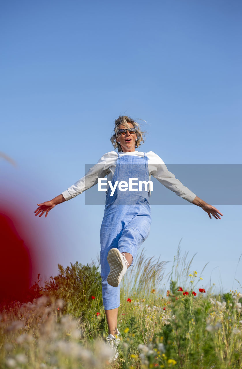 full length of young woman standing on field