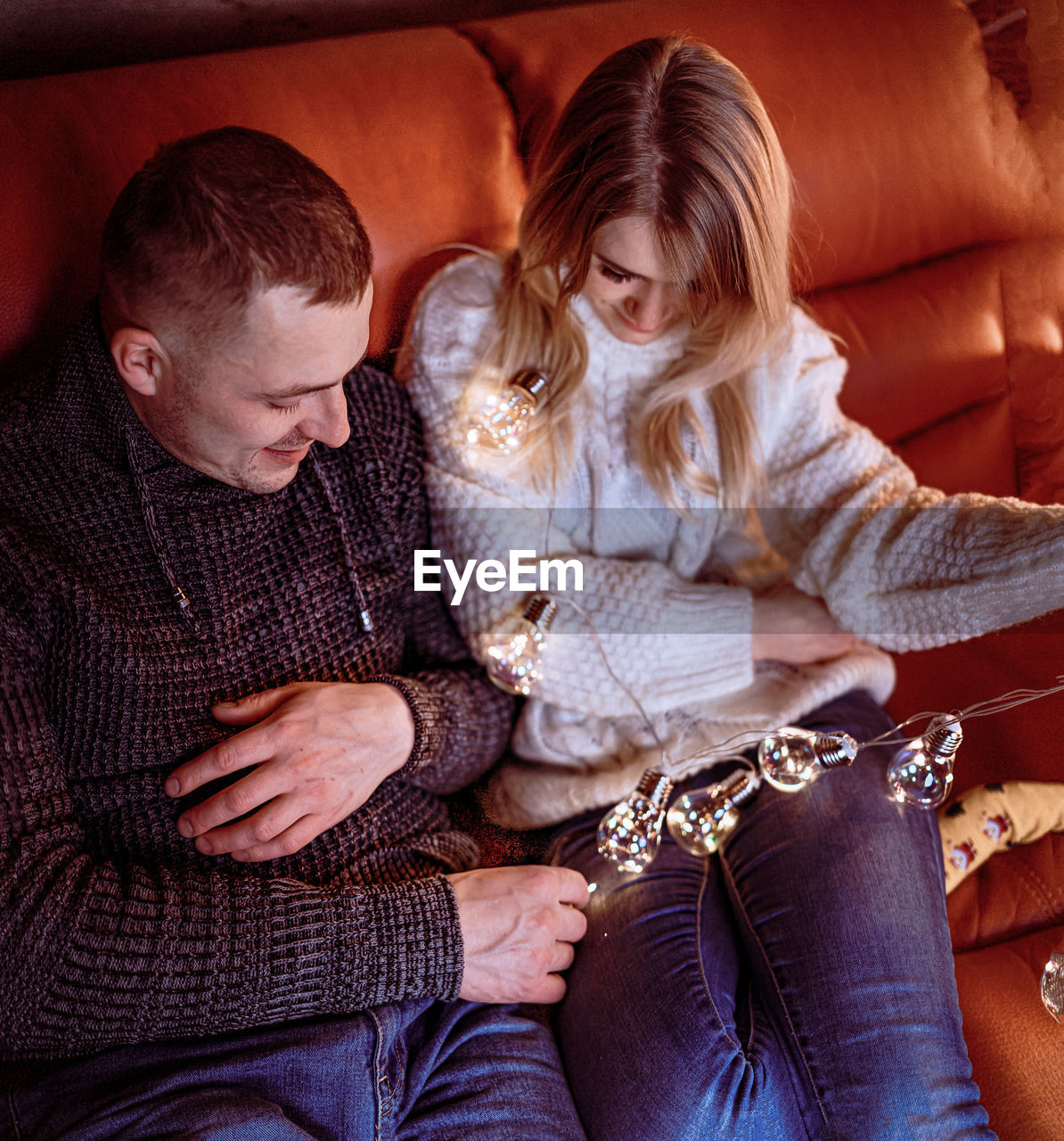 YOUNG COUPLE SITTING IN SOFA