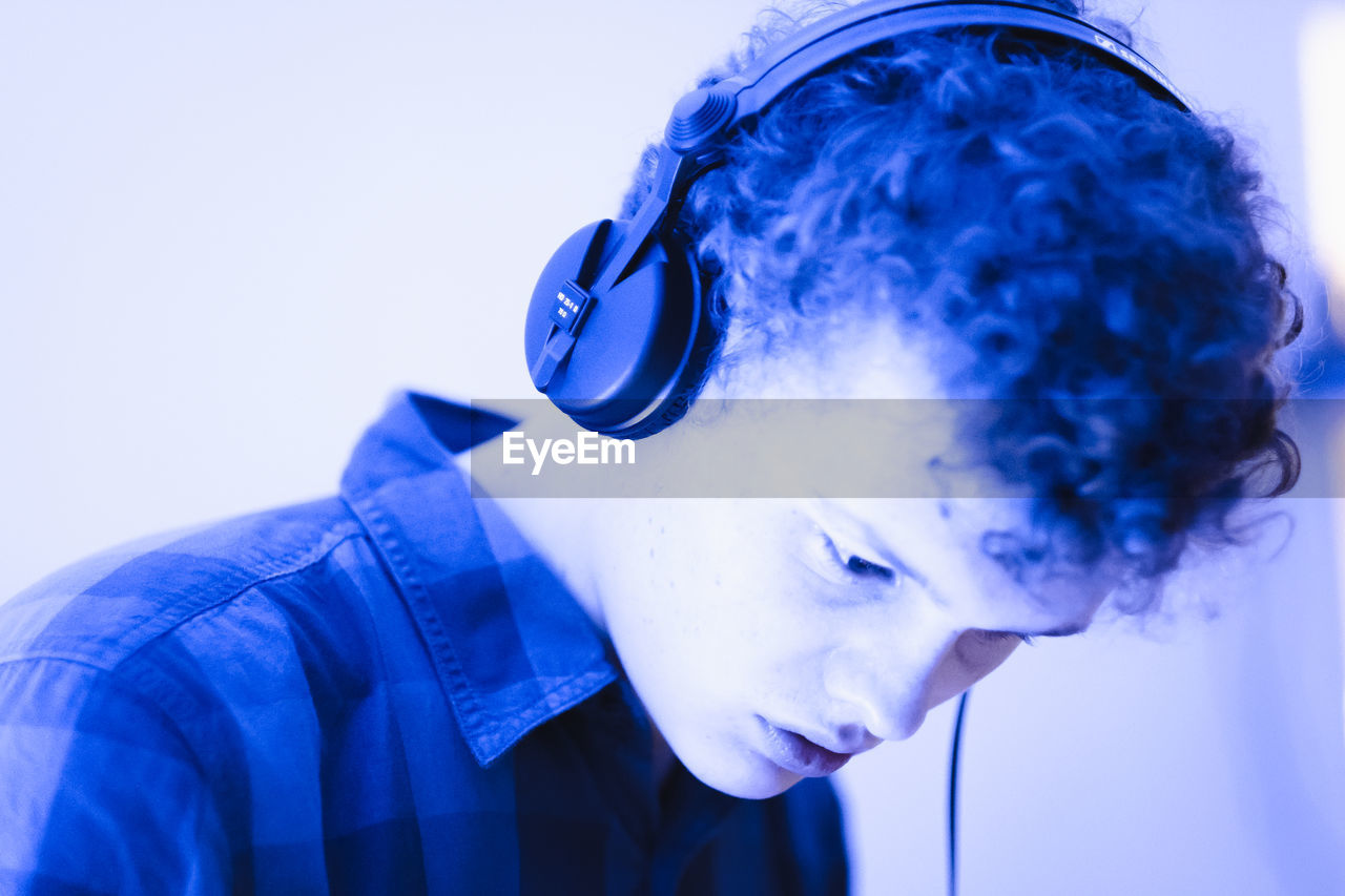 Close-up of young man listening music