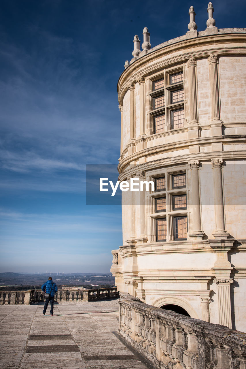 MAN STANDING AT HISTORICAL BUILDING