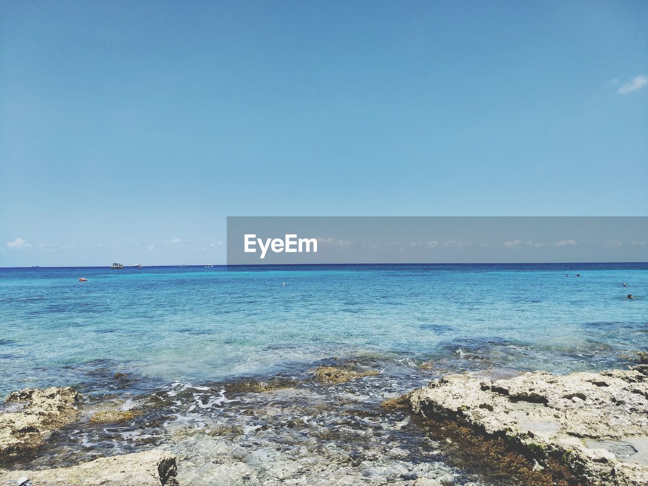 Scenic view of sea against blue sky during sunny day