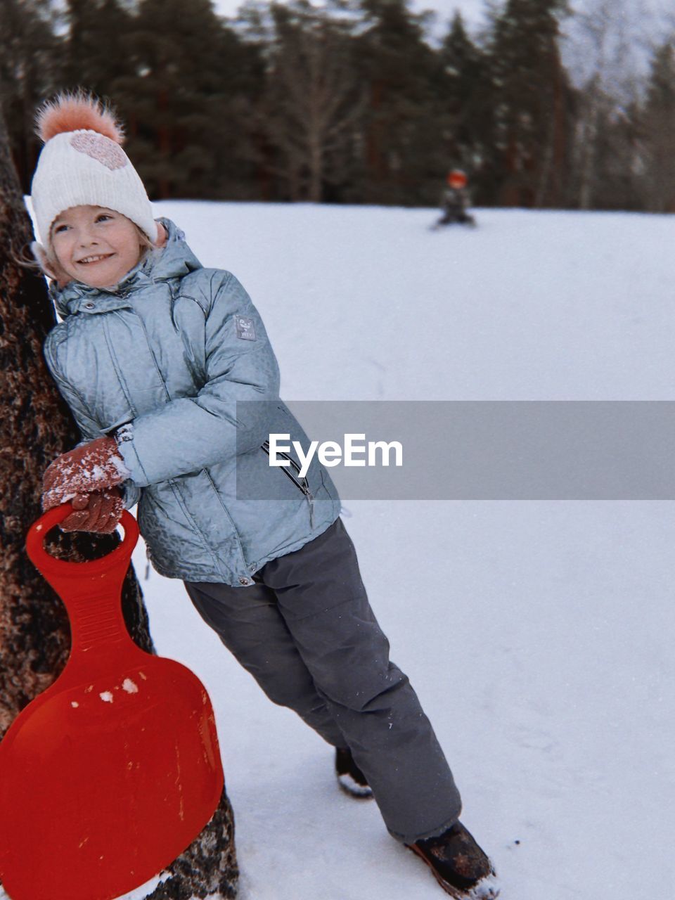 Portrait of young man skiing on snow covered field