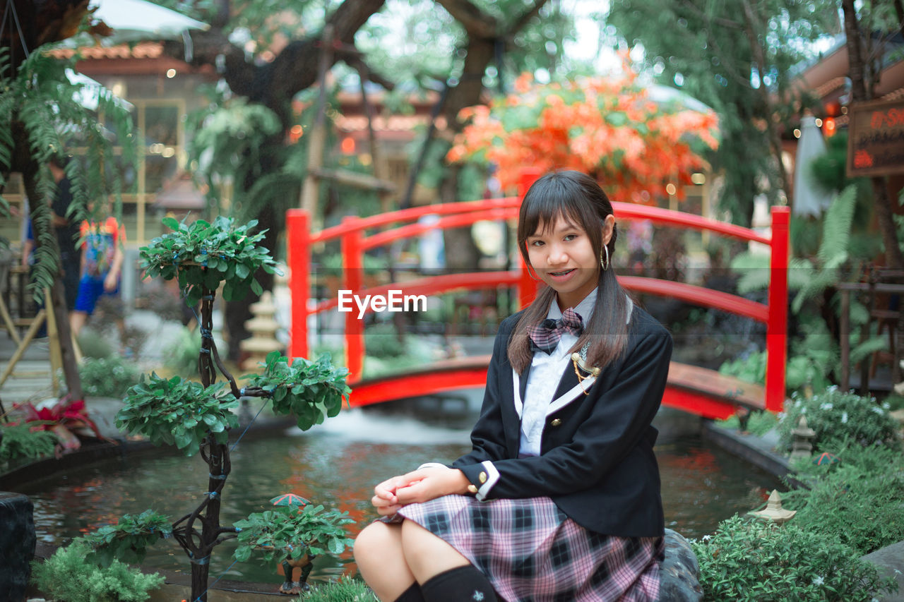 Portrait of teenage girl sitting at park