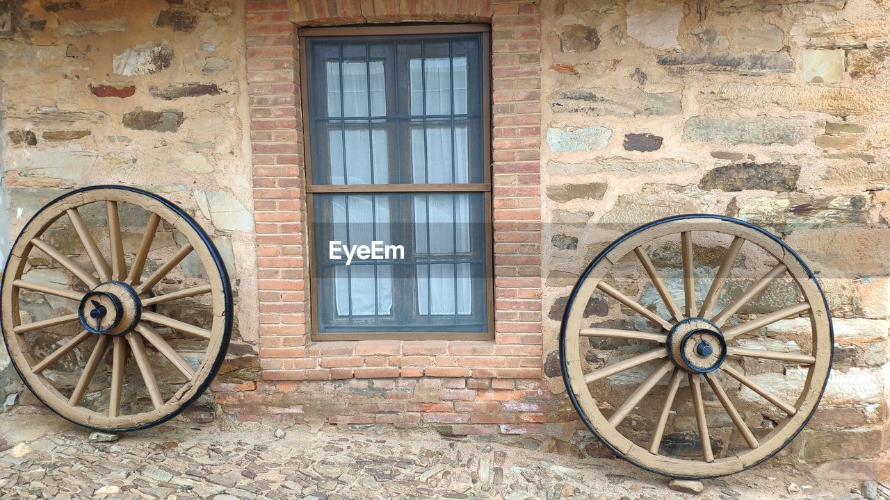 Window, wheels and stone wall