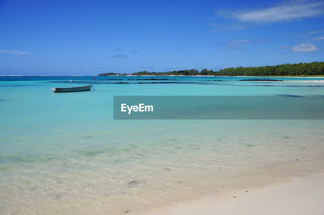 Scenic view of beach against blue sky