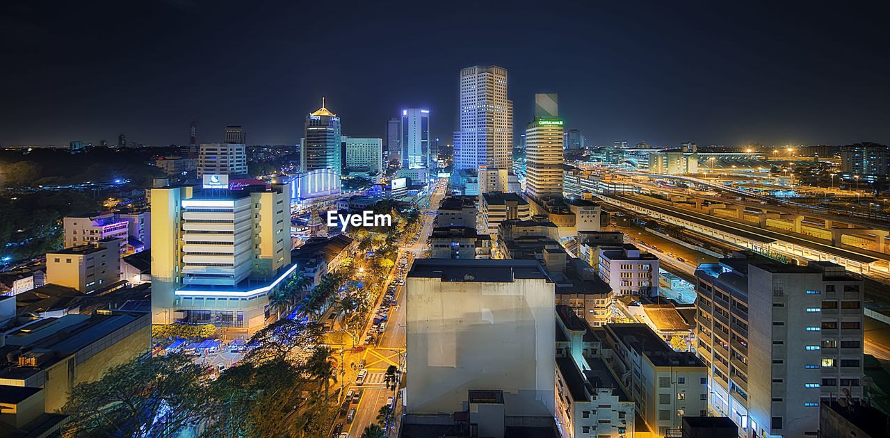 ILLUMINATED MODERN BUILDINGS IN CITY AT NIGHT