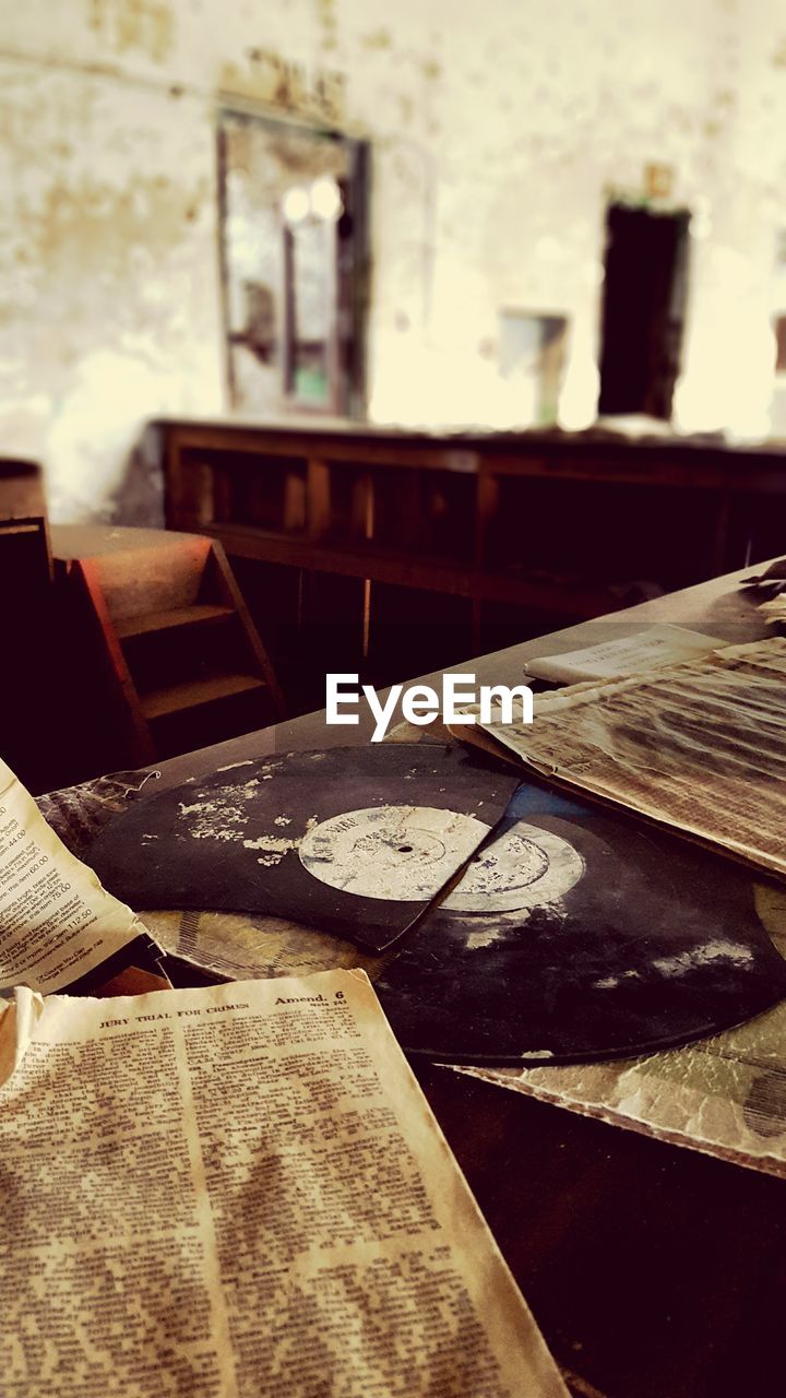 Newspapers on table in abandoned house