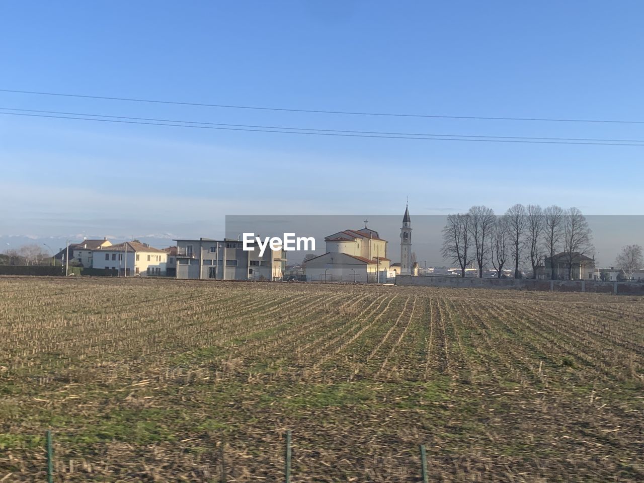 sky, architecture, land, landscape, field, built structure, agriculture, rural area, nature, plant, rural scene, building exterior, building, farm, horizon, no people, environment, house, day, growth, plain, electricity, tree, hill, crop, outdoors, cable, scenics - nature, prairie, blue, technology