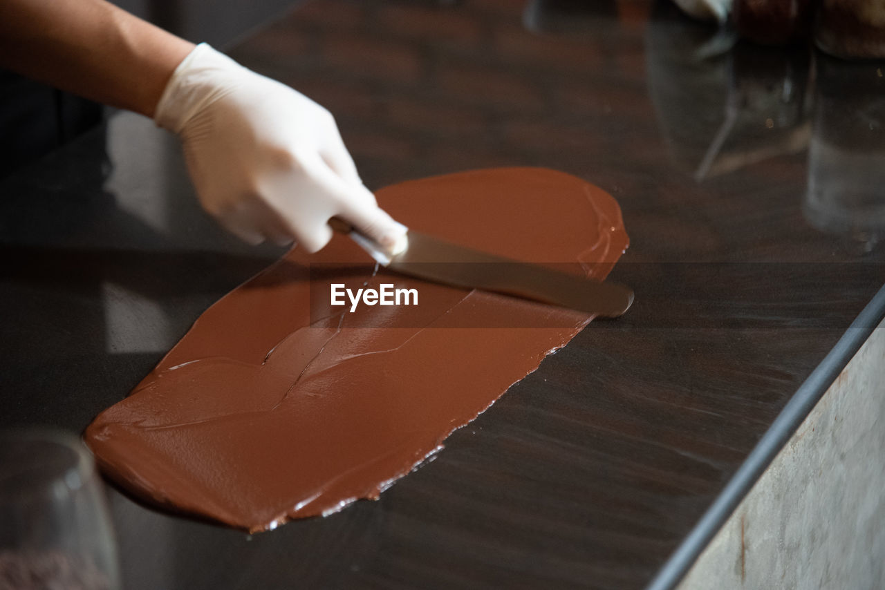 MIDSECTION OF PERSON PREPARING FOOD ON TABLE