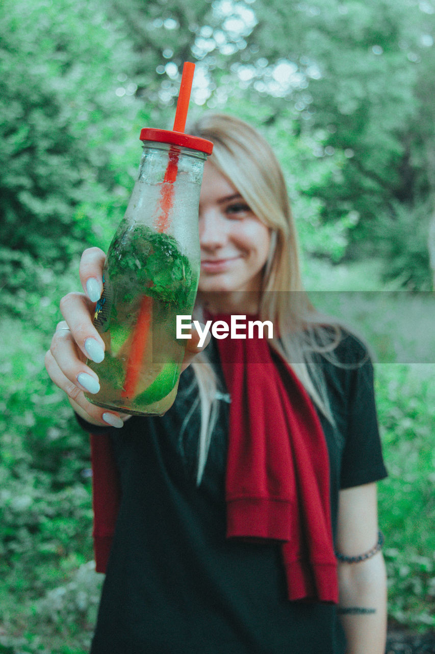 Midsection of woman drinking glass