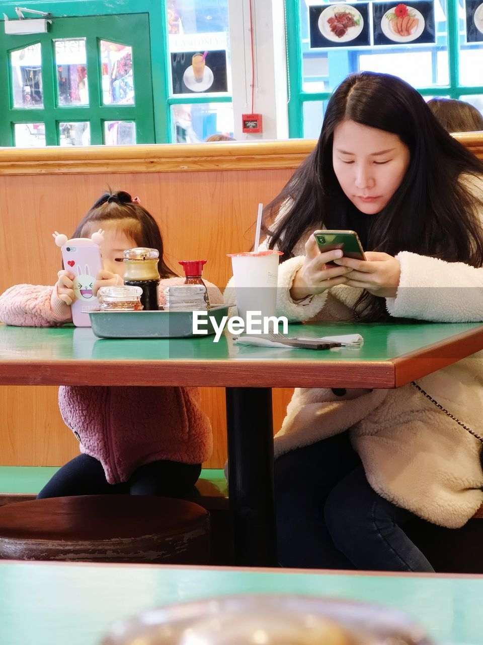 YOUNG WOMAN SITTING IN A RESTAURANT