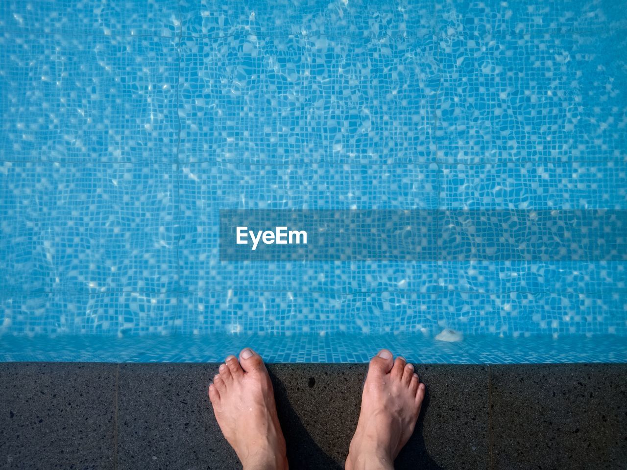 Low section of person standing on poolside