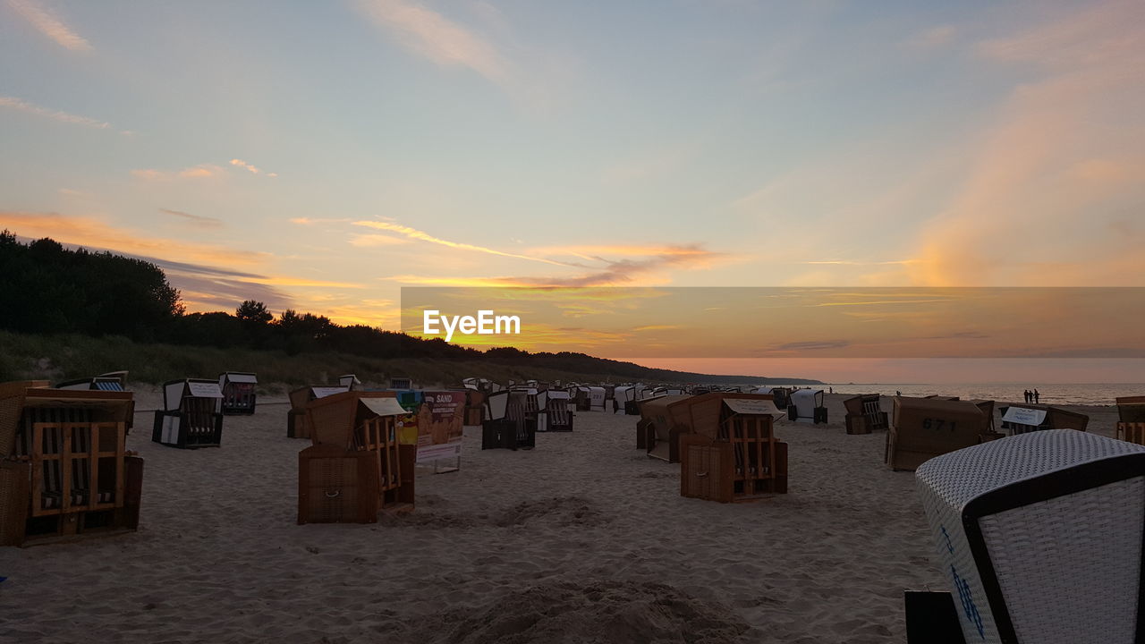 HOODED CHAIRS ON BEACH DURING SUNSET