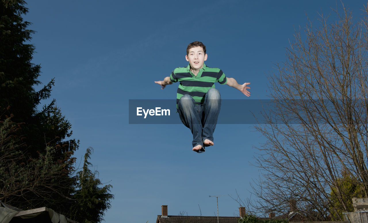 Boy jumping on trampoline in woking - england