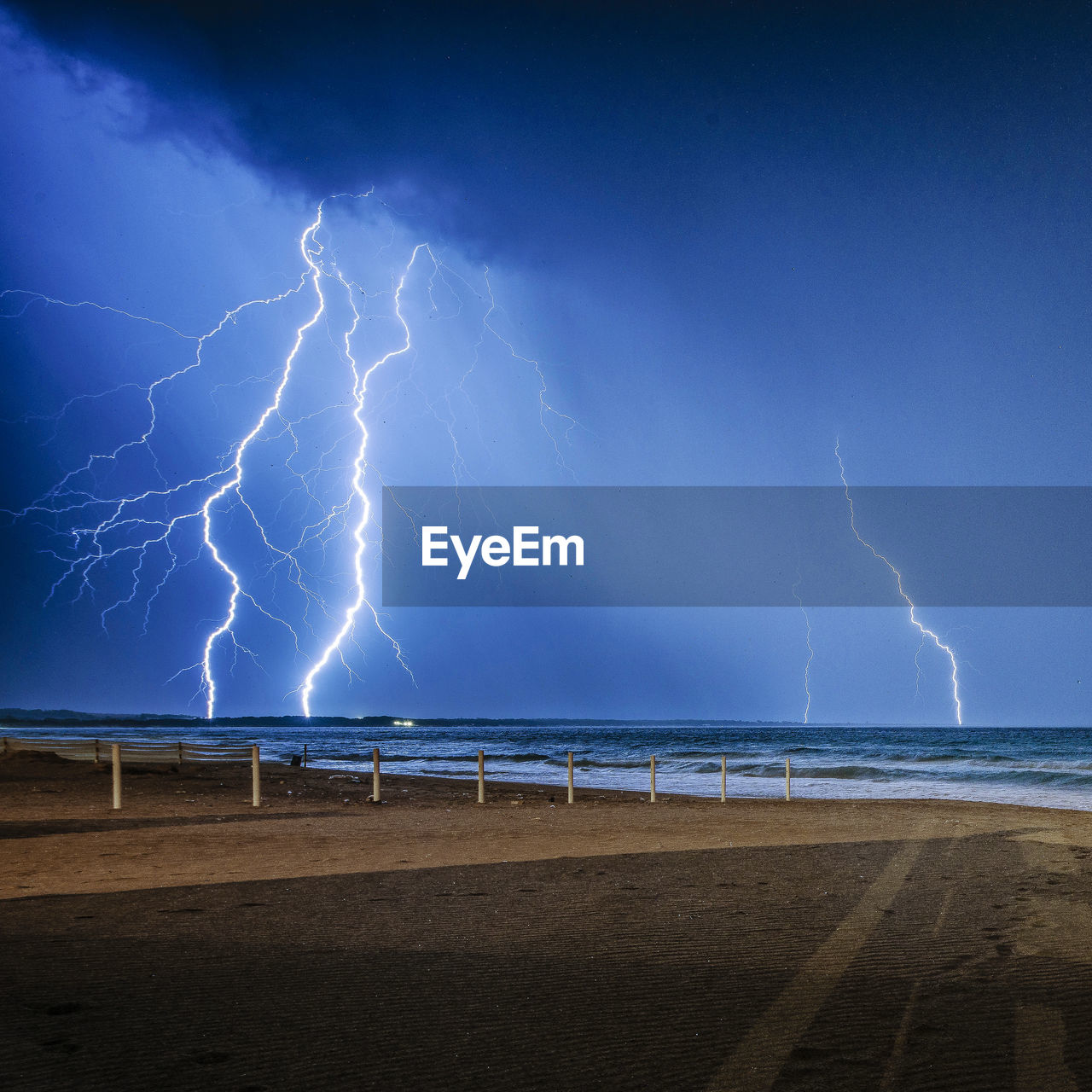 Lightning over sea against sky at night