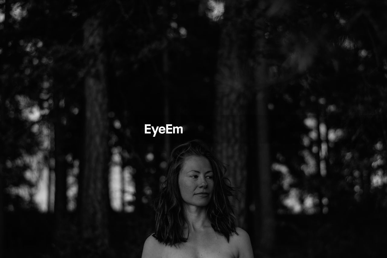 Shirtless woman at forest