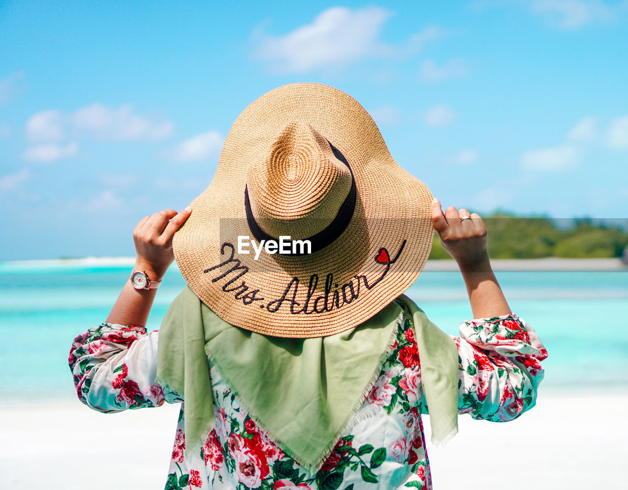 Rear view of woman wearing hat against sea