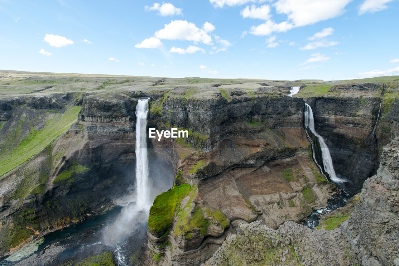 SCENIC VIEW OF WATERFALL ON MOUNTAIN