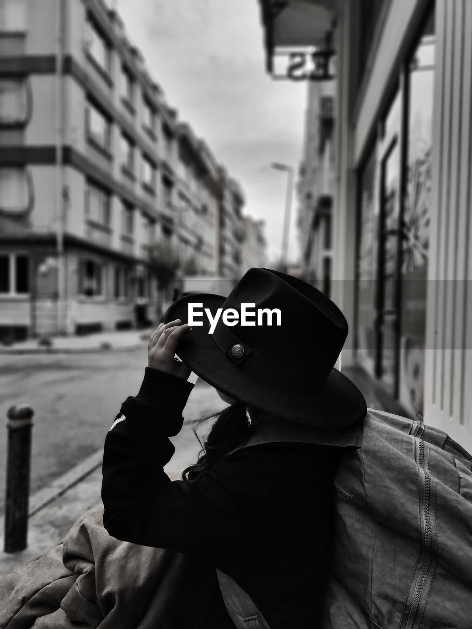 side view of man wearing hat while standing in city