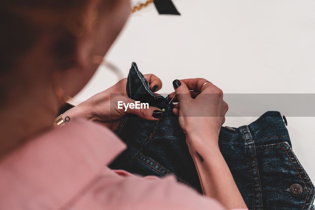 Midsection of woman sewing jeans