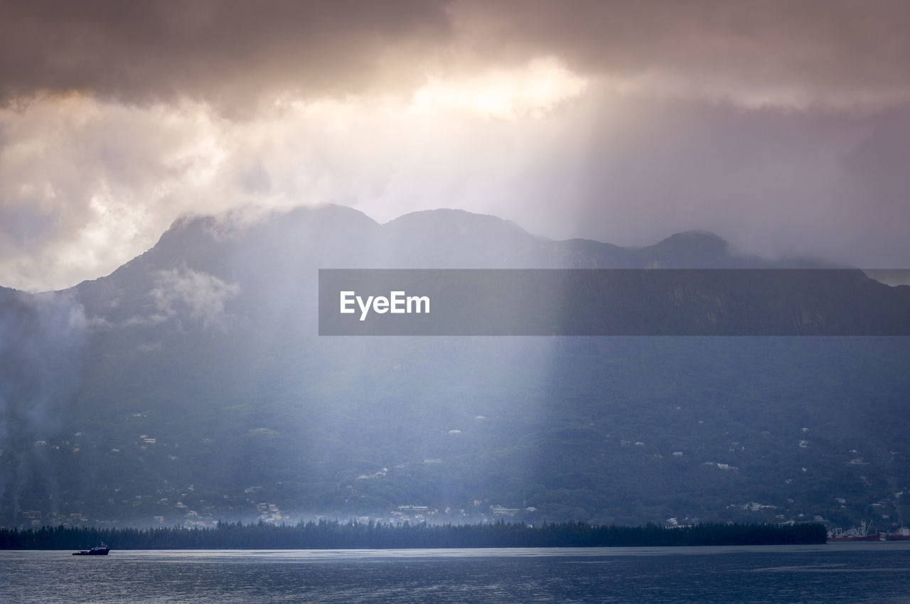 Scenic view of mountains against cloudy sky