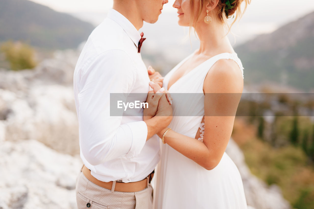 Midsection of couple standing outdoors