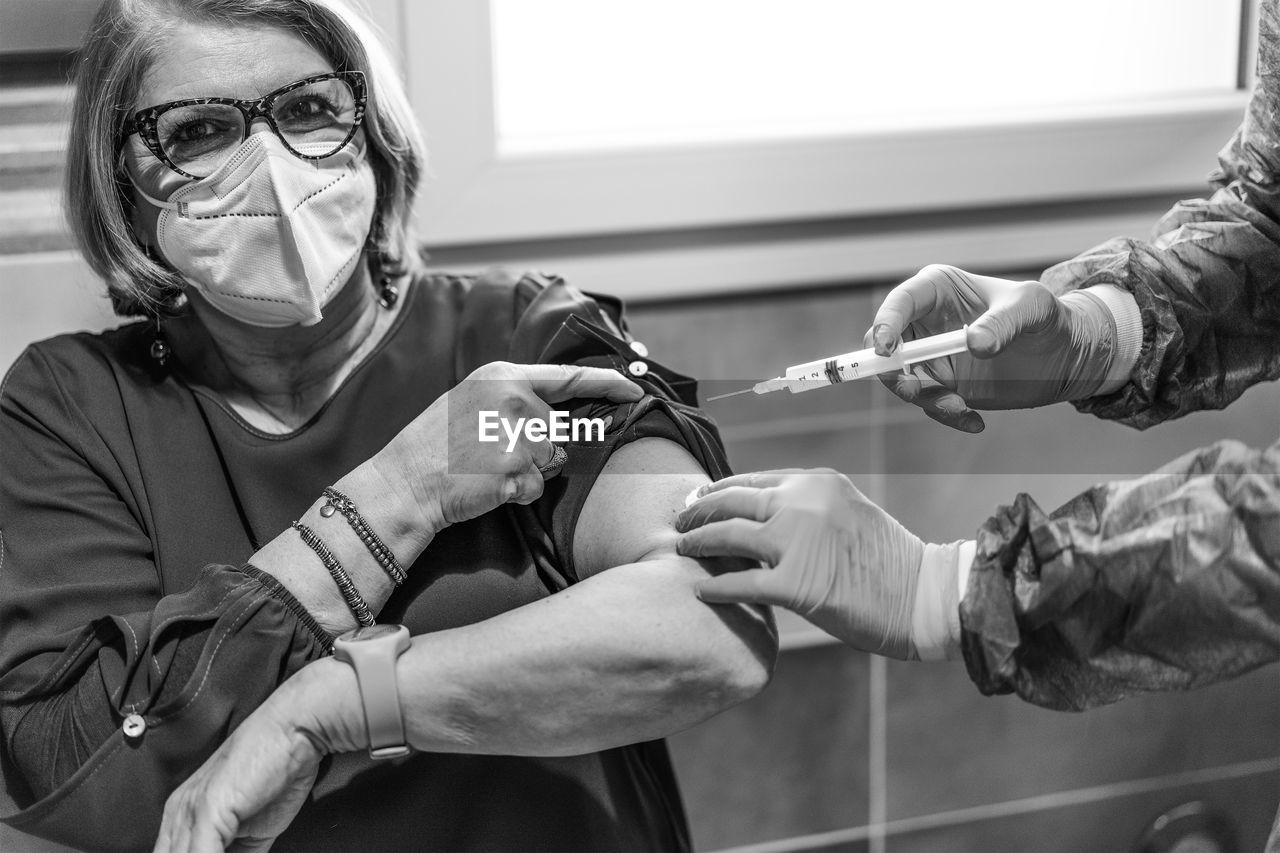 Cropped hands of doctor giving injection to patient