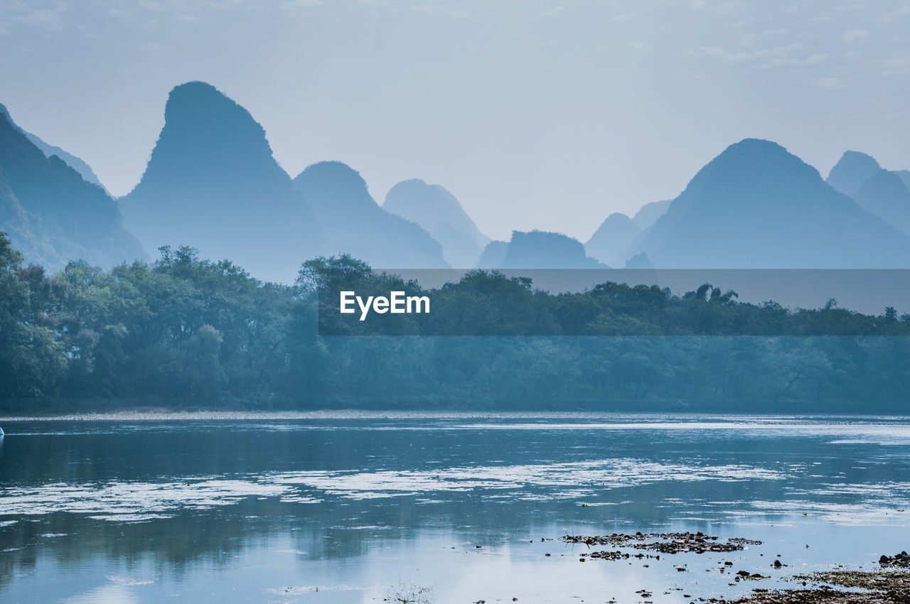 Scenic view of lake by mountains against sky