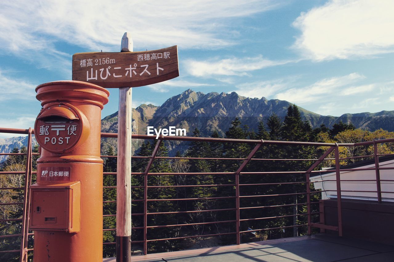 INFORMATION SIGN AGAINST MOUNTAIN RANGE