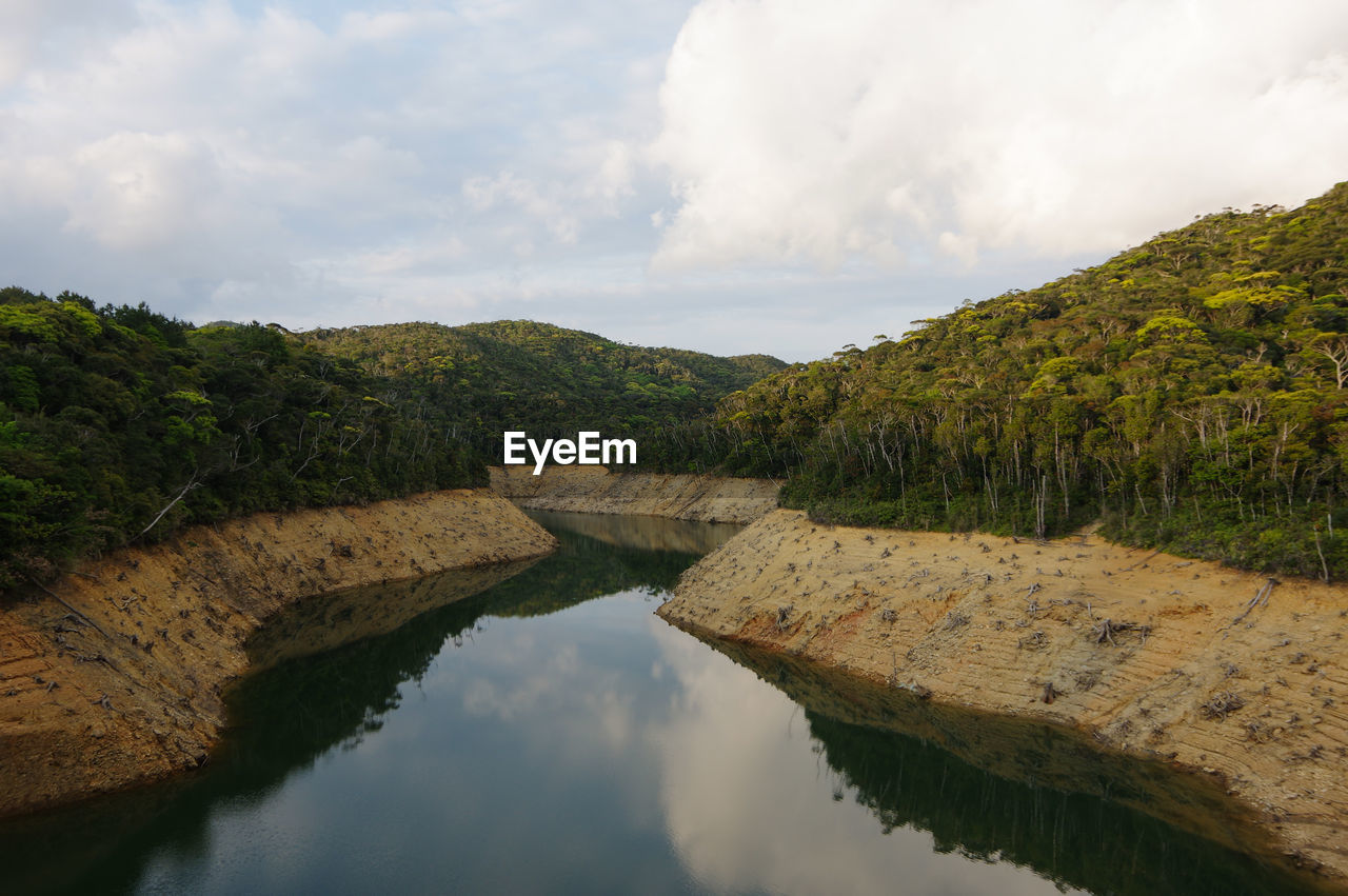 water, reflection, river, nature, cloud, sky, environment, reservoir, scenics - nature, landscape, beauty in nature, body of water, no people, tranquility, land, tree, travel destinations, plant, travel, outdoors, forest, tourism, mountain, tranquil scene, non-urban scene, architecture, waterway, day, wilderness, rock