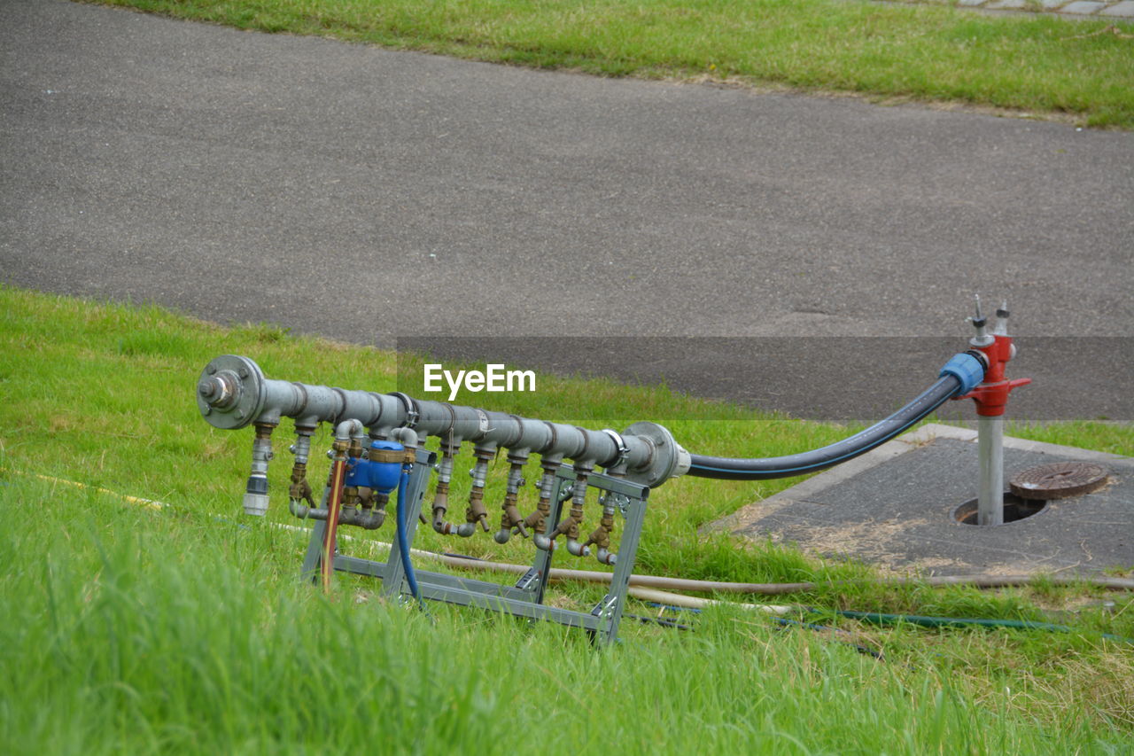 Close-up of pipeline on grassy field