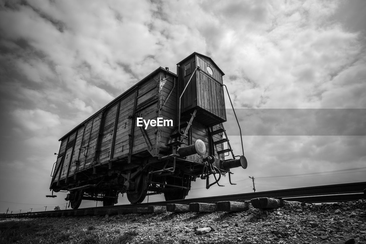 Low angle view of abandoned vehicle on field against sky