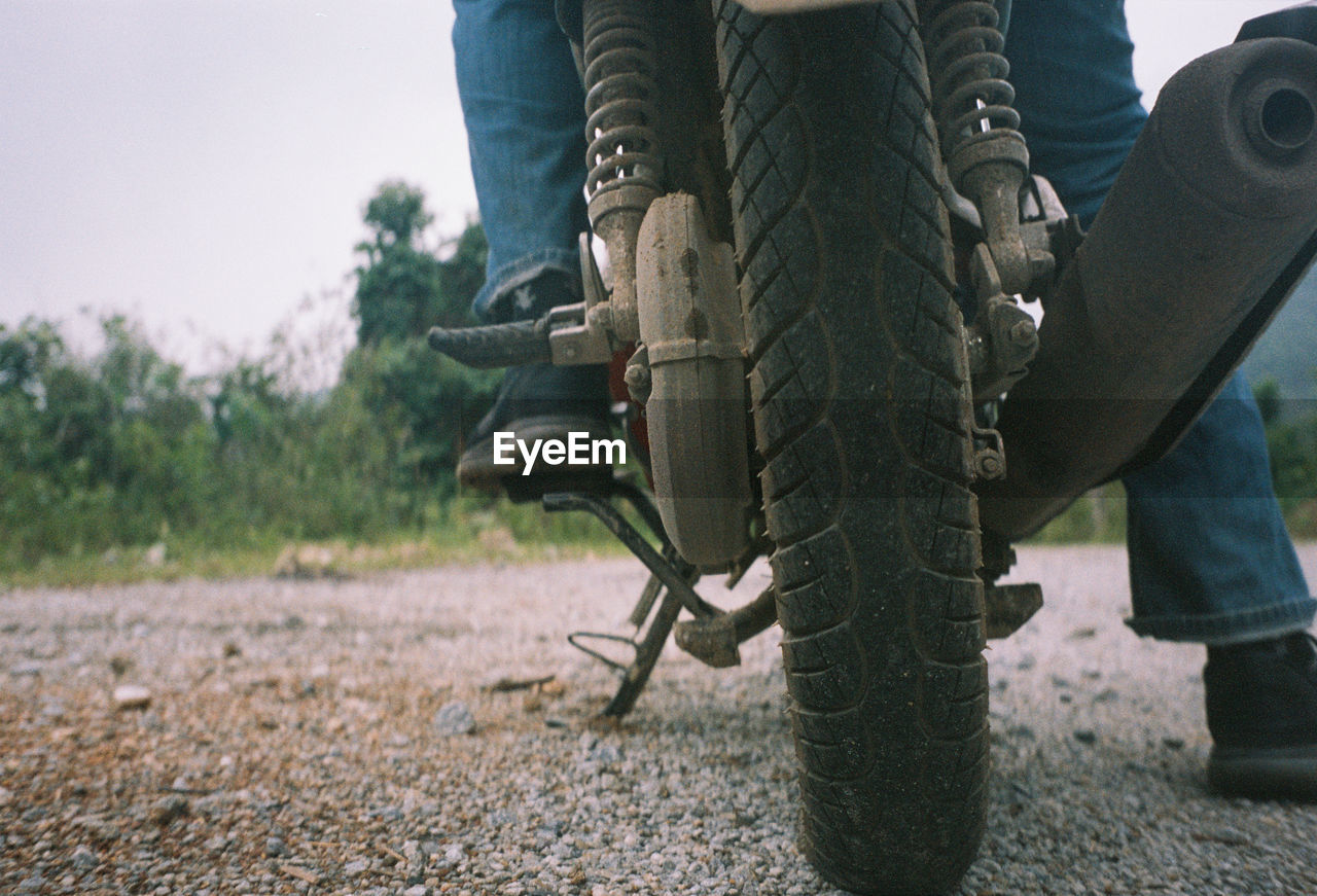 Low section of man on motorcycle at road 