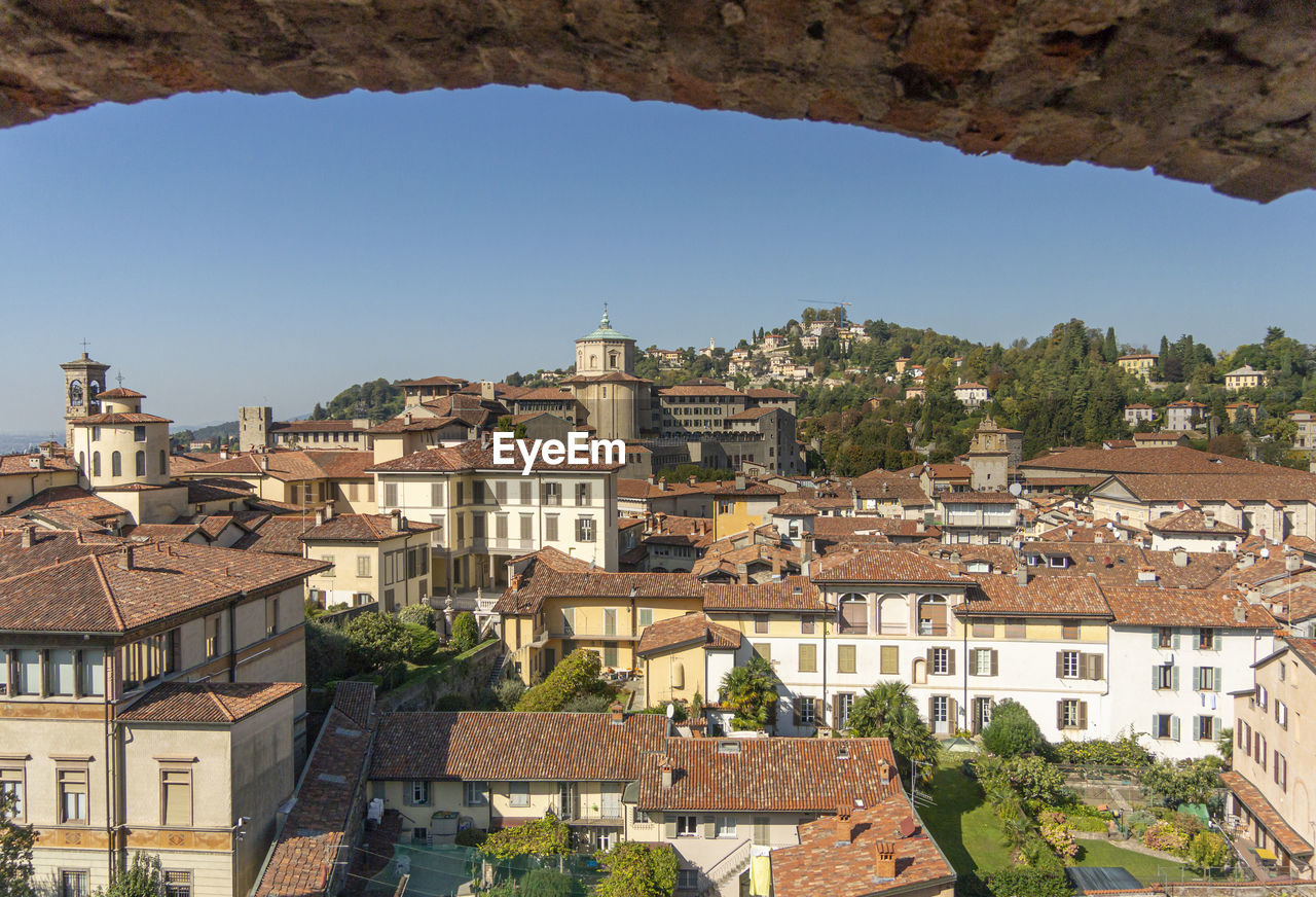Aerial view through a stone arch, of the old town of bergamo, italy