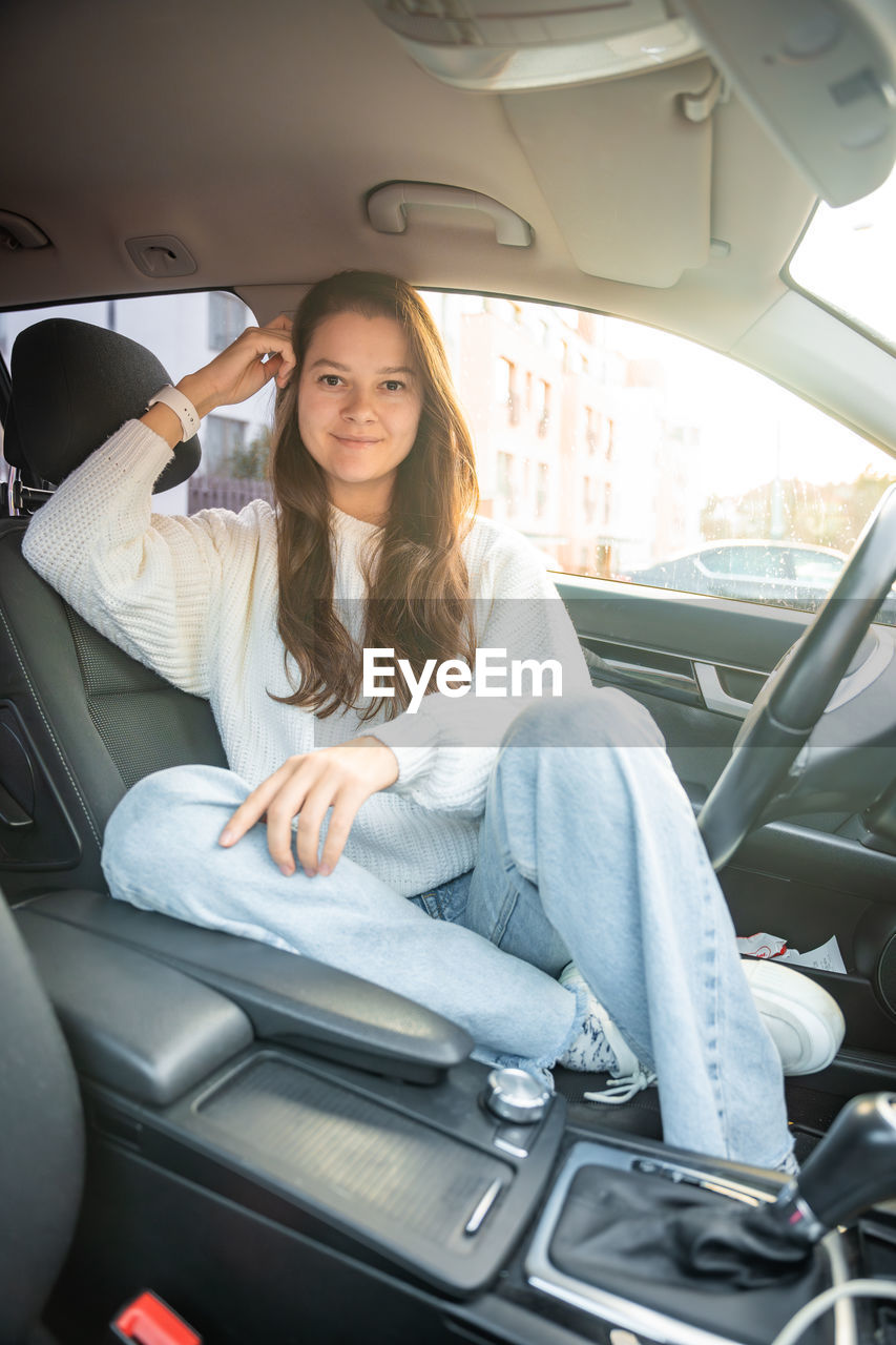 portrait of smiling young woman sitting in car