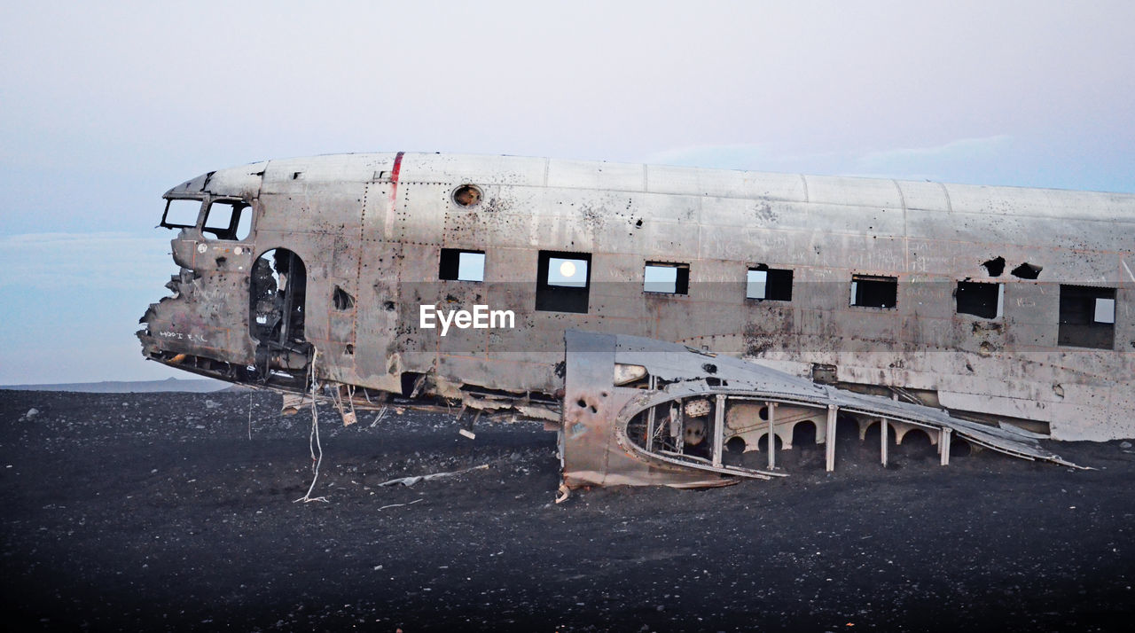 Abandoned airplane on runway against sky