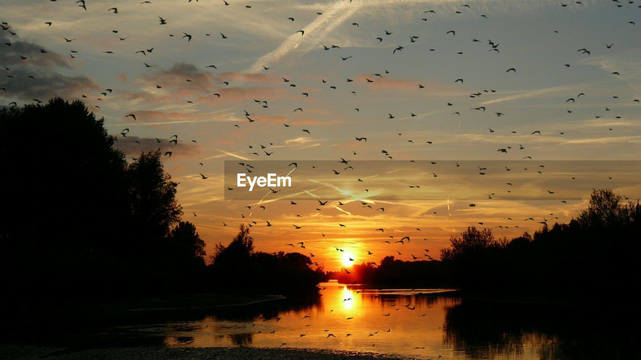 SCENIC VIEW OF LAKE AGAINST ORANGE SKY