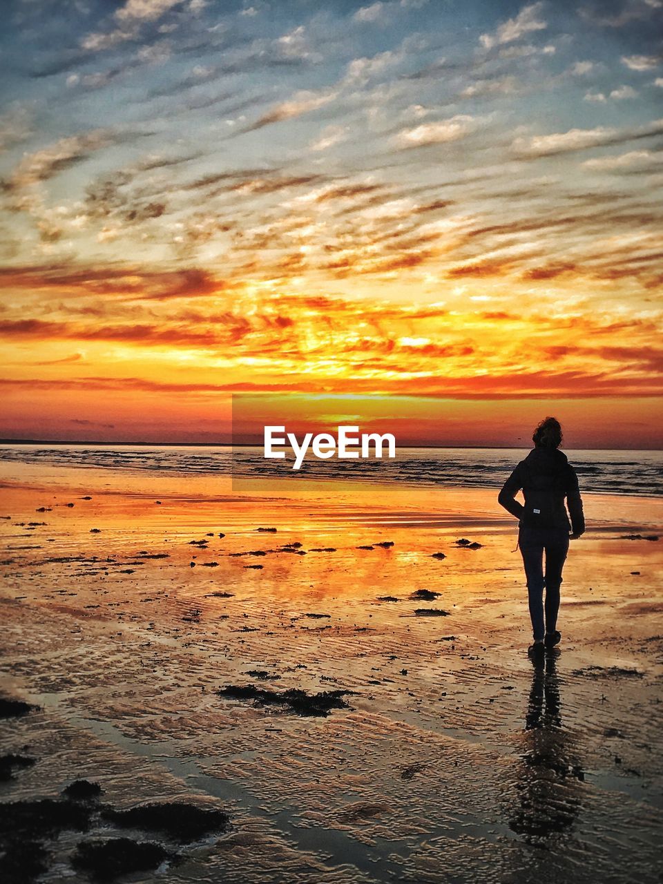 SILHOUETTE WOMAN STANDING ON BEACH AGAINST SKY DURING SUNSET