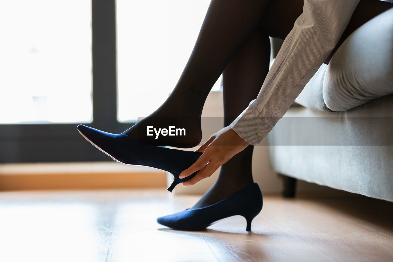 low section of woman tying shoelace on floor