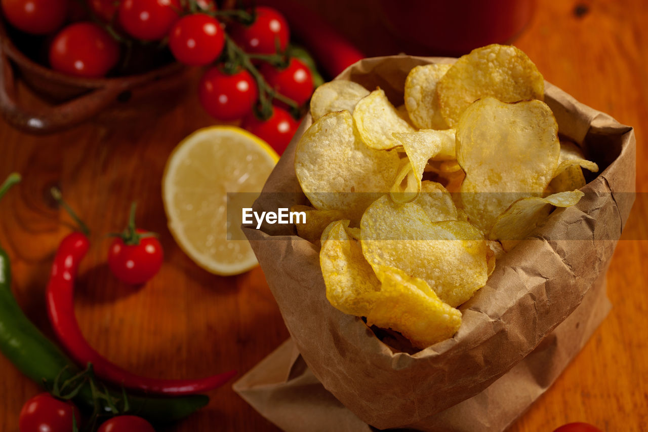 Close-up of potato chips with cherry tomatoes on table