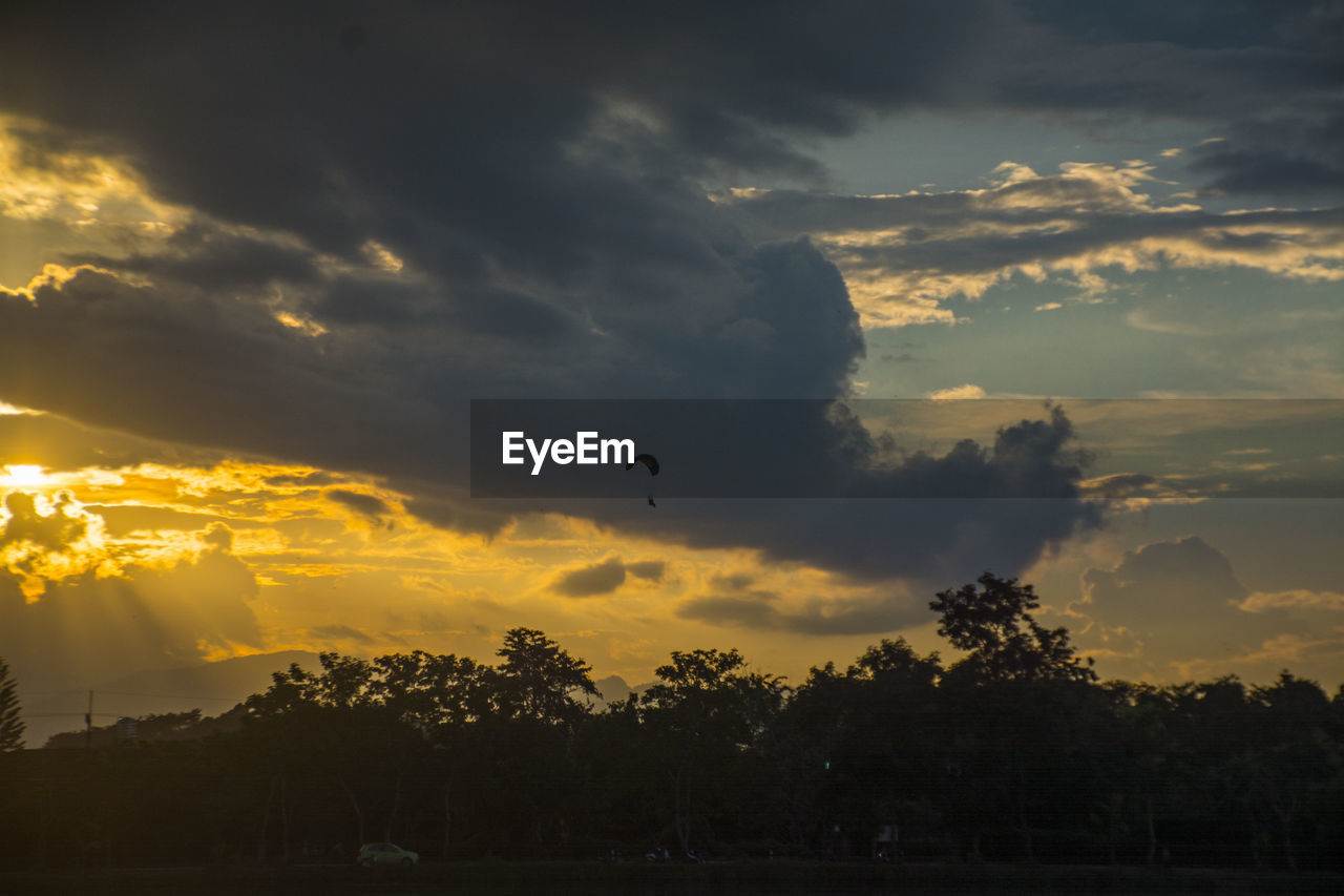 SILHOUETTE OF BIRDS FLYING IN SKY DURING SUNSET