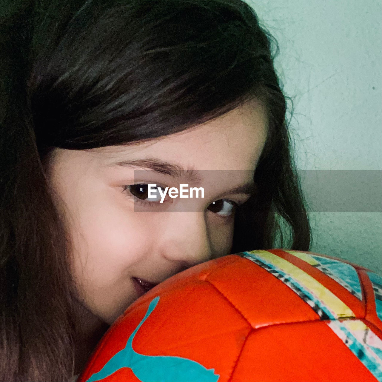 portrait, one person, sports, soccer, team sport, child, football, soccer ball, ball, sports equipment, looking at camera, headshot, childhood, teenager, human face, women, person, human head, hairstyle, red, lifestyles, female, emotion, adult, athlete, indoors, leisure activity, close-up, nose, brown hair, sports uniform, clothing
