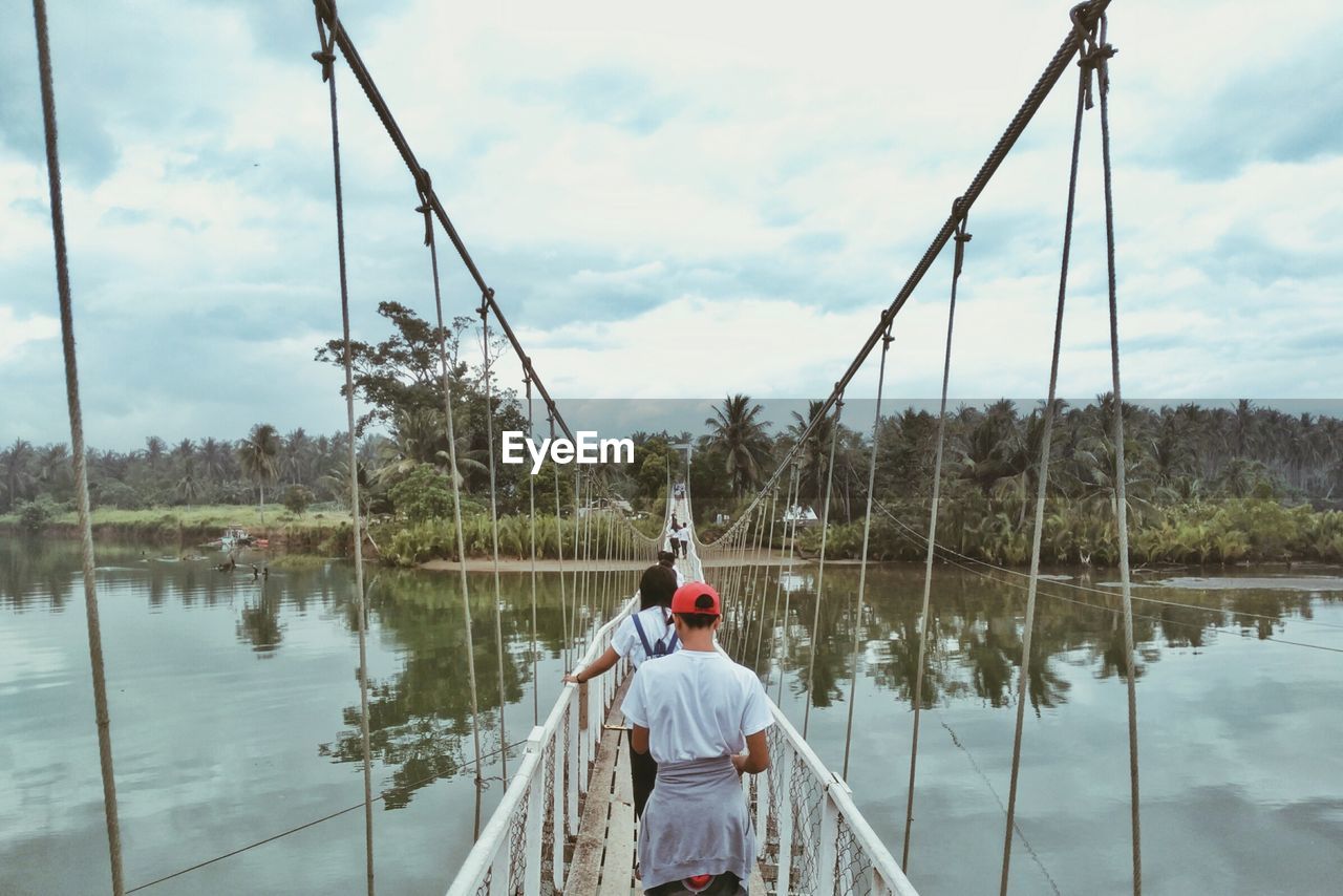 Rear view of man walking on the bridge