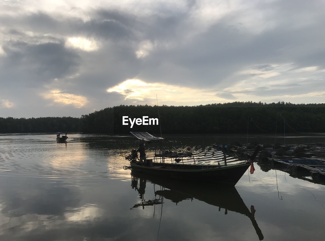 SAILBOATS IN LAKE AGAINST SKY