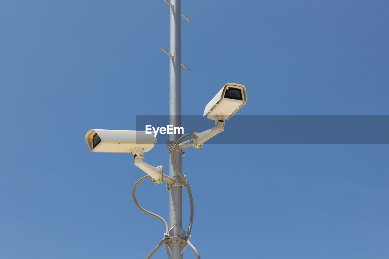 low angle view of security camera against clear sky