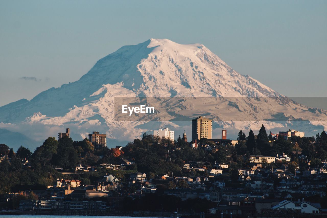 View of cityscape against snowcapped mountain
