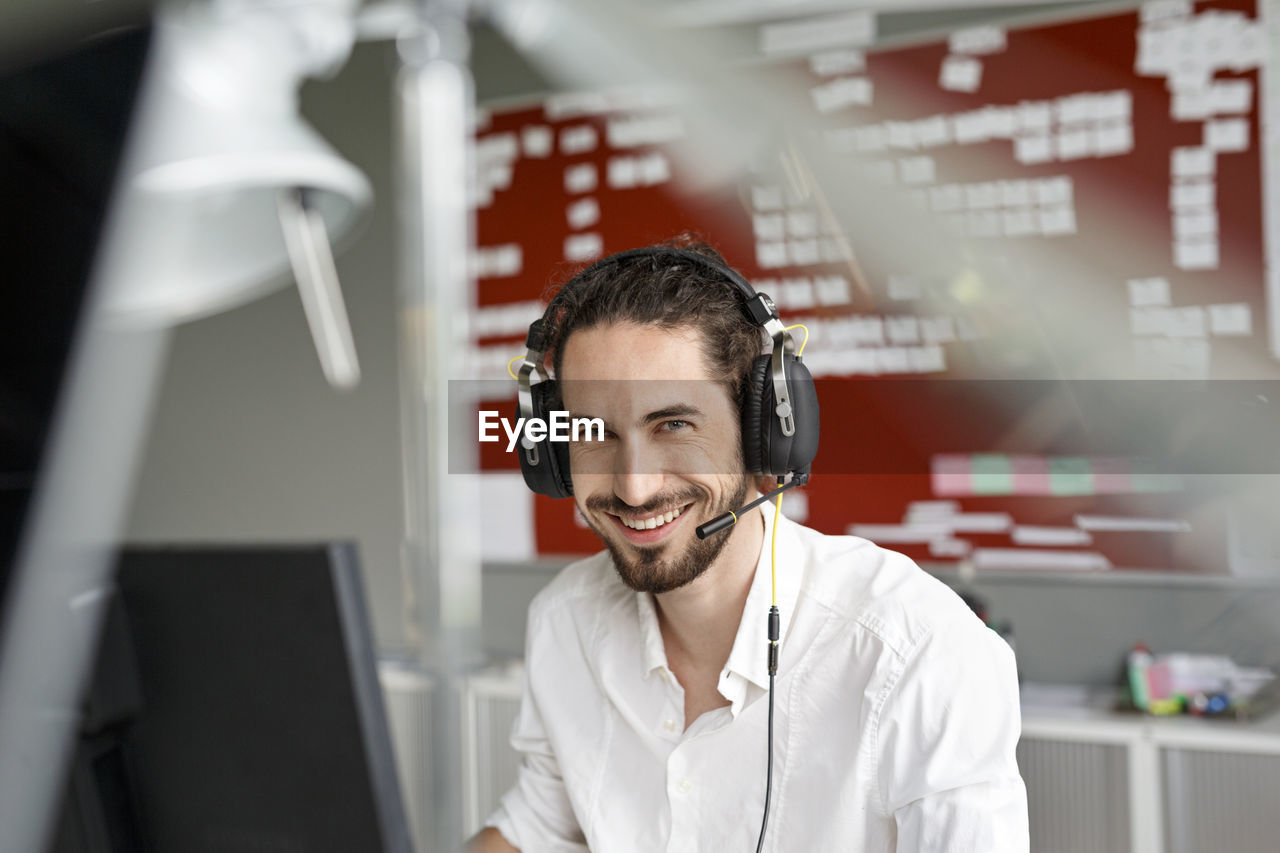 Smiling man in office with headset