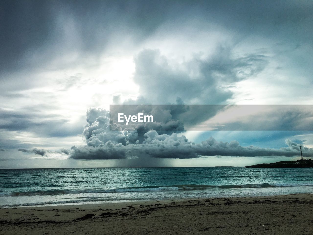 Scenic view of beach against cloudy sky