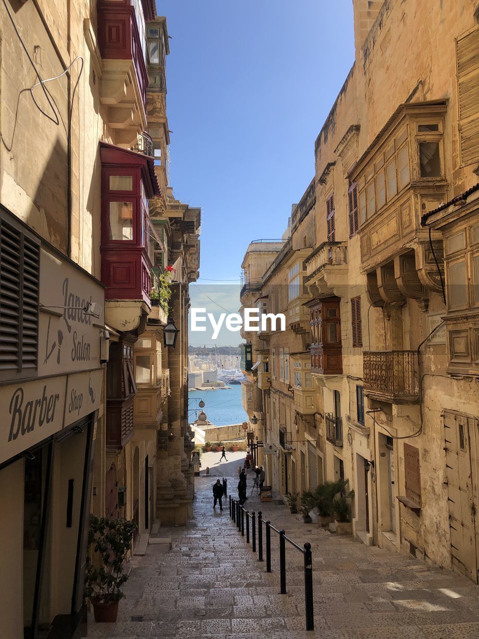 PEOPLE ON STREET BY BUILDINGS AGAINST SKY IN CITY